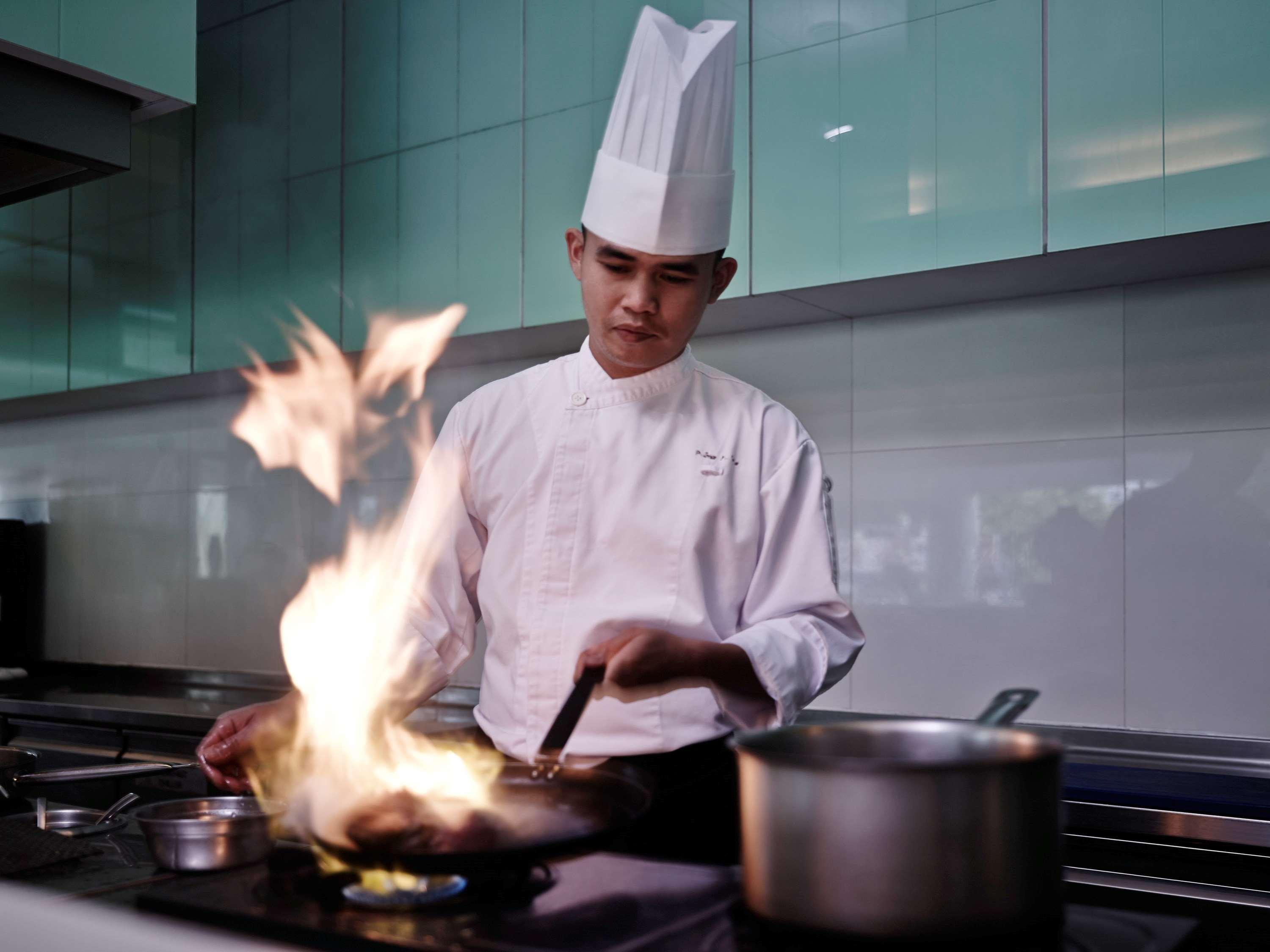 Hotel Pullman Kuching Extérieur photo A chef cooking with a flaming wok